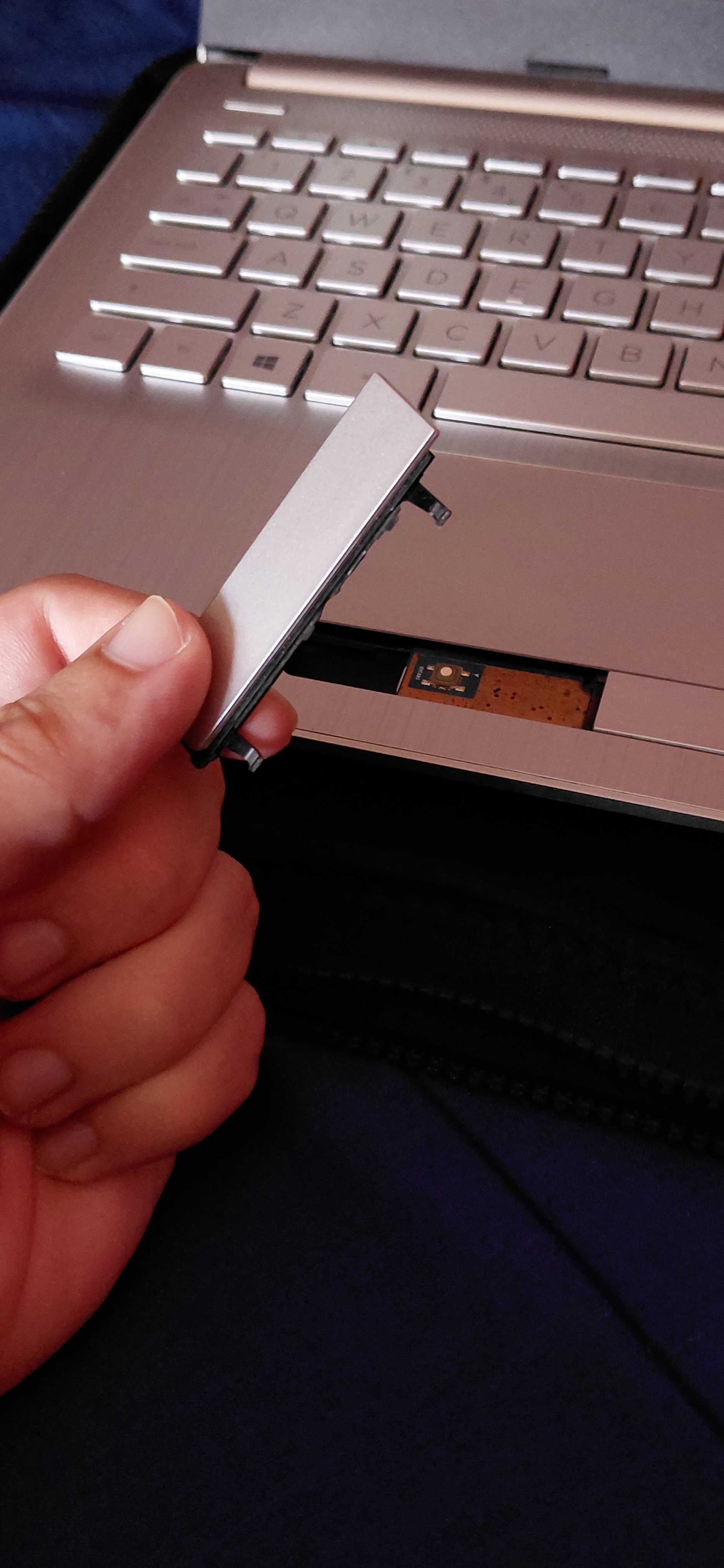 The old HP laptop with a chassis that's falling apart. I am literally holding a piece of plastic from the touchpad that just broke off one day due to cheap plastic the company used.